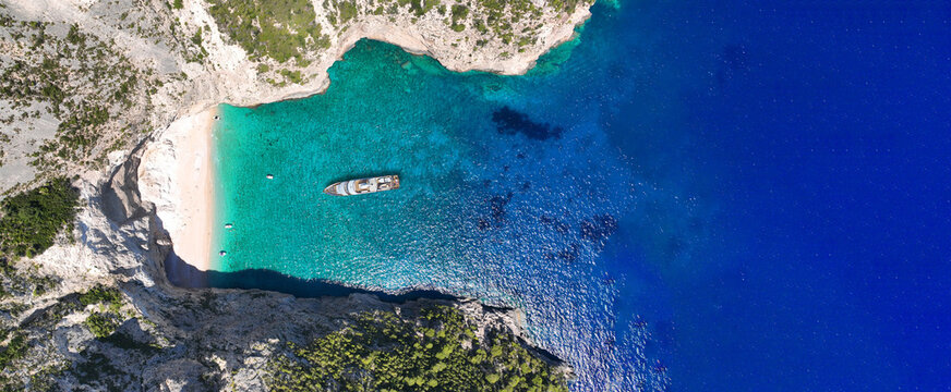 Aerial drone ultra wide panoramic top down photo with copy space of luxury yacht anchored in tropical exotic island with crystal clear turquoise sea