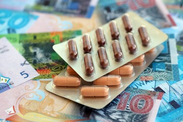 Kuwaiti dinar currency money bills and medicine pills close up. The concept of medicine and pharmacy