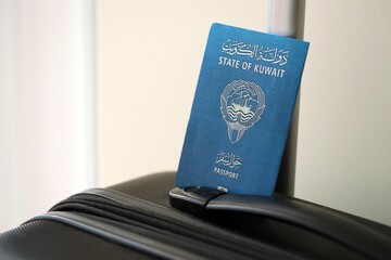 Kuwaiti passport on travel luggage close up. The concept of travel and vacation