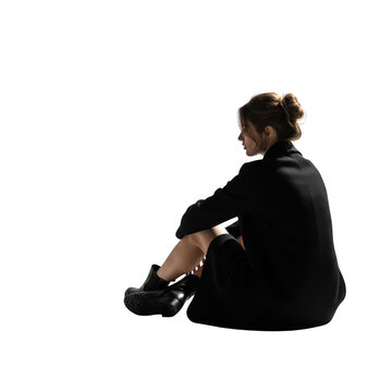 Woman in black clothing sitting and looking back isolated on transparent background