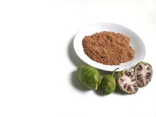 Noni or Morinda Citrifolia powder and fruits on white background.