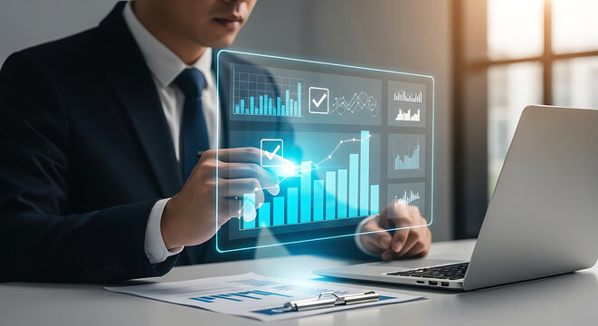 Businessman analyzing financial data on a digital interface with charts and graphs next to a laptop in an office.
