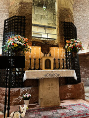Church altar in Assisi Italy with candles flowers and ornate lace cloth
