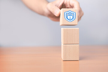 A wooden block with a security lock icon represents the concept of data protection, privacy and cybersecurity, demonstrating the creation of a strong security foundation for digital information.