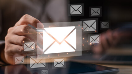 A digital concept image showing a person touching a glowing email icon with multiple envelopes, symbolizing online communication, email marketing, digital networking, business communication technology