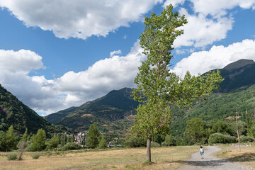 Tourist walking towards San Juan de Plan. Gistaín Valley. Huesca