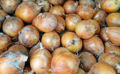 A full frame shot of a fresh pile of brown onions in a cardboard box