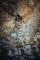 Limestone vein analysis, Geological study of textured wall, Examination of mineral veins and sediment layers, Closeup view showcasing fractures and mineral patterns on limestone surface