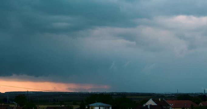 Dark Rain Clouds Roll In to Cover a Pastel Horizon Bringing Showers Over a Quiet Rural Landscape Captured in Moody 4K Time Lapse Emphasizing Weather Transition and Approaching Storm