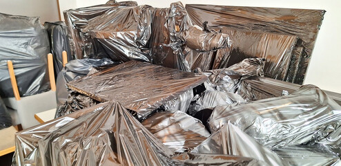 The objects are packed in black plastic bags. Protection from dust and breakage by polyethylene film. Panorama.