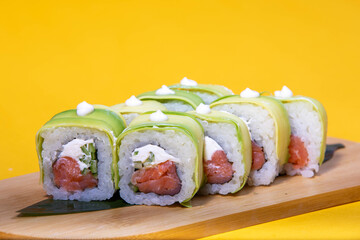 High-quality close-up of fresh salmon and tuna sushi rolls served on a black ceramic plate. Ideal for Japanese restaurant menu design.
