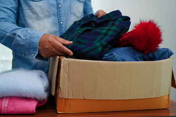 Clothes donations in cardboard box for volunteer.