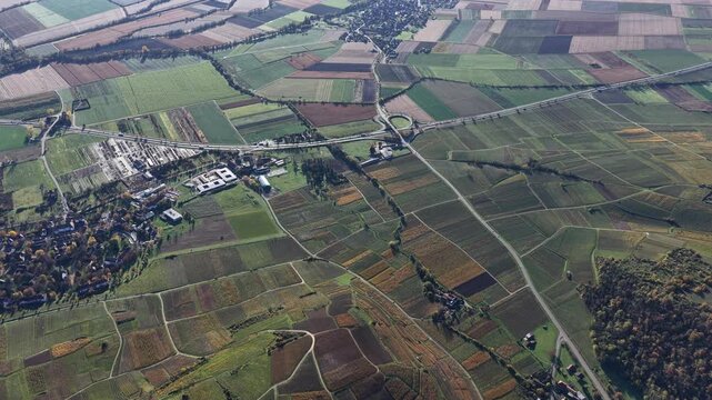Aerial view of the landscape showing vineyards, buildings, and roads, creating a tapestry of textures and tones, Rouffach, Grand Est, France.