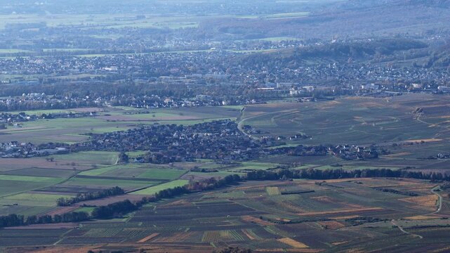 Aerial view of the patchwork of vineyards and fields surrounding the quaint town, a tapestry of earth tones, Rouffach, Grand Est, France.