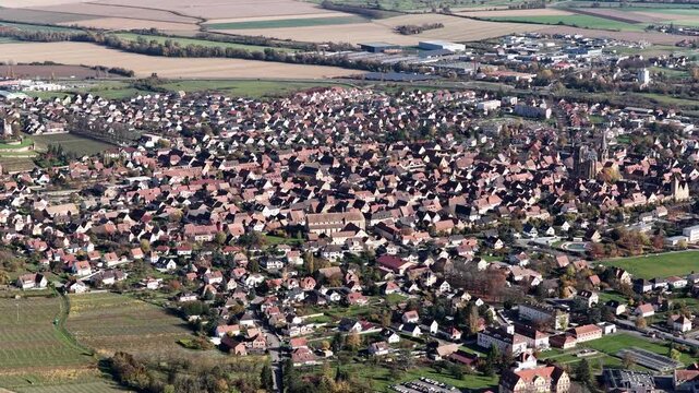 Aerial view of the sprawling town of Rouffach, featuring a dense collection of buildings and a prominent church, Rouffach, Grand Est, France.