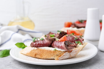Delicious bruschettas with roast beef served on light table, closeup. Space for text