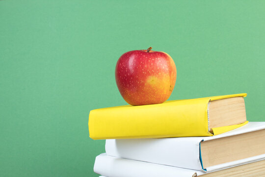 Books stacking. Books on wooden table and green background. Back to school. Copy space for ad text.