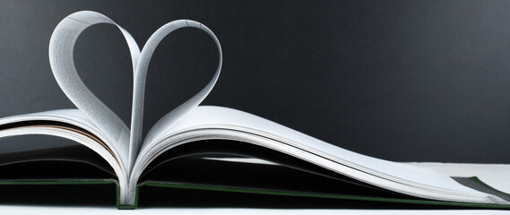 Old open hardback book, page decorate into a heart shape for love in Valentine's. love with open book heart.