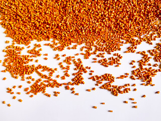 Orange masterbatch granules, cold cutting type, polymer carries color pigment poured into a white background medium, suitable for product catalog design of industrial plastic company profiles