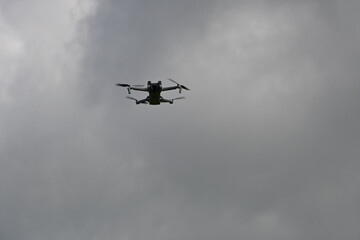 A drone hovering mid-air with a sky backdrop. Small drone with the sky background 