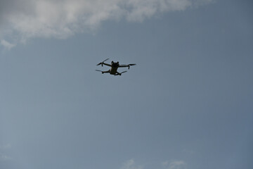 A drone hovering mid-air with a sky backdrop. Small drone with the sky background 