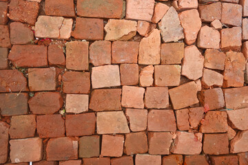 Textured close-up of uneven red brick blocks set in ground as paving, showing raw material arrangement and rustic craftsmanship for flooring backgrounds.