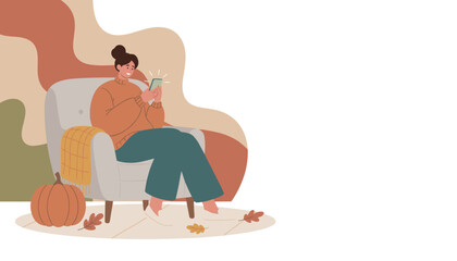 Cozy autumn relaxation Woman sitting in armchair smiling while using her smartphone