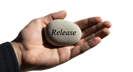 Hand holding a stone with the word 'Release' 