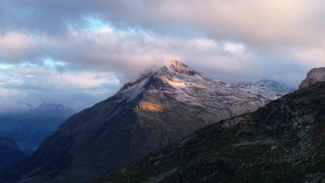 Sunrise lights Swiss Alps peaks with clouds, serene landscape beauty