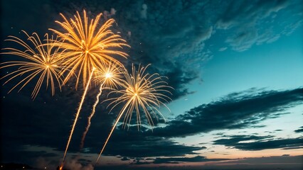 A dazzling night sky illuminated by golden-yellow fireworks bursting in radiant patterns. Their glowing trails and vibrant light contrast beautifully with the deep blue and teal hues of the evening sk