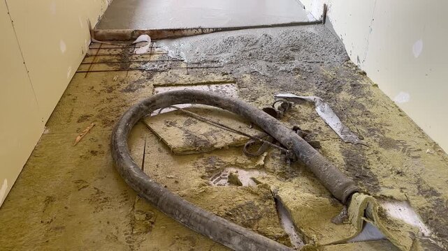 Shot of a pipe and concrete slab just poured. Expansion joint in the cement floor. View of the layers on a wooden slab. Wool insulation and rebars on clt floor, ready to pour concrete.