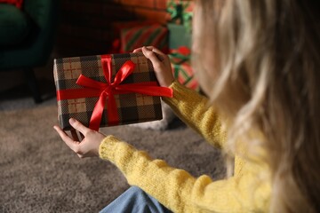 Woman with Christmas gift at home, closeup