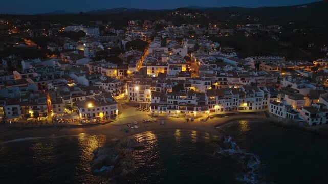 night drone shot of famous Spanish beach resort on Costa Brava coast, Calella de Palafrugel fishing village in Catalunya, holiday in Costa Brava