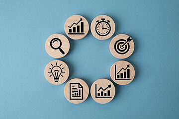 Business strategy planning process with growth charts and icons on wooden circles light blue background