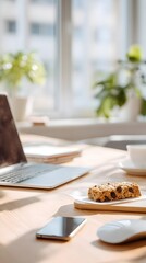 Healthy snack break at workplace with laptop, granola bar and coffee cup on wooden desk in morning sunlight, productive lifestyle concept