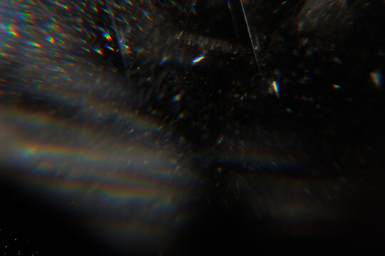 Easy to add lens flare effects for overlay designs or screen blending mode to make high-quality images. Abstract sun burst, digital flare, iridescent glare over black background. Defocused dark bokeh.