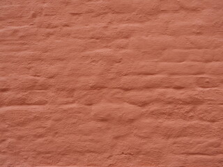 Matte reddish-orange brick wall with rough texture and visible joints. Copyspace