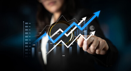 A business professional engages with a digital growth chart, symbolizing success and strategic analysis in a modern corporate financial environment. Scalp