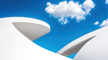 White modern architecture curves under a bright blue sky with fluffy cloud