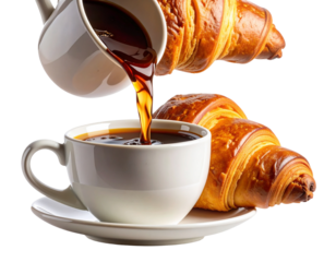 Freshly brewed coffee being poured into a white cup next to golden croissants
