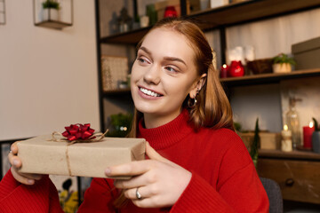 Cozy day at home with a young woman holding a gift in a warm and inviting atmosphere