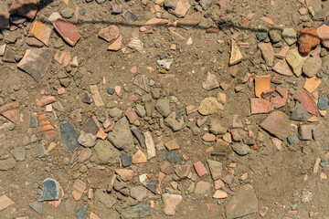 Archaeological pottery shards and stones in desert soil, Elephantine Island, Egypt