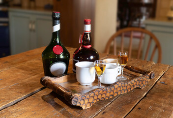 Coffee cups and liqueurs on a wooden table. Coffee in a country house.