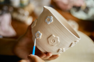 Close up hand of woman painting her pottery ceramic