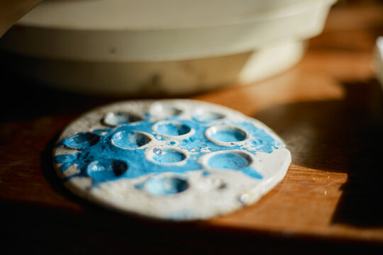 artist's palette, texture mixed ceramic paints - Powered by Adobe