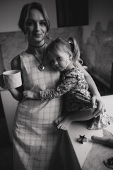 A mother and daughter are cooking in the kitchen. A mother and daughter are spending the pre-holiday evening cooking.