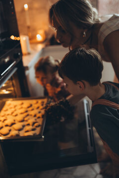 A mother and her children are preparing delicious food in the kitchen on the eve of the holiday. Children and their mother are cooking
