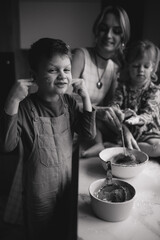 A mother and her children are preparing delicious food in the kitchen on the eve of the holiday. Children and their mother are cooking