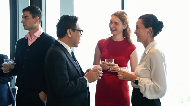 Diverse business colleagues in a friendly, professional conversation during a corporate networking event or New year party. Successful team members building connection and enjoying a social gathering