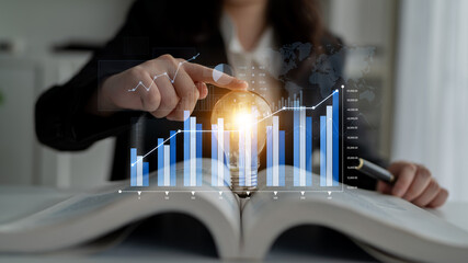 A professional explores business innovation with a glowing light bulb and financial graphs in a...